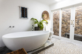 Modern bathtub with houseplant against white wall in bathroom at home, copy space - PhotoDune Item for Sale