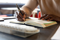 Midsection of african american mature businessman writing in diary at desk in office - PhotoDune Item for Sale