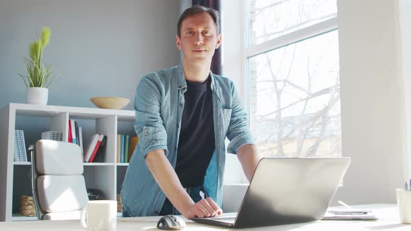 Young male entrepreneur works at home office at the computer.