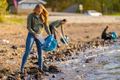 Dedicated young volunteers cleaning beach on sunny day - PhotoDune Item for Sale