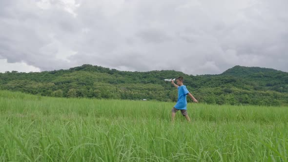 Boy Walking In Rice Field With Airplane