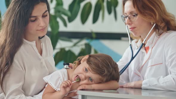 Female Doctor Pediatrician Using Stethoscope Listen To the Heart of Happy Healthy Cute Kid Girl