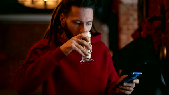 A Handsome Homosexual Man Drinks Coffee in a Cafe