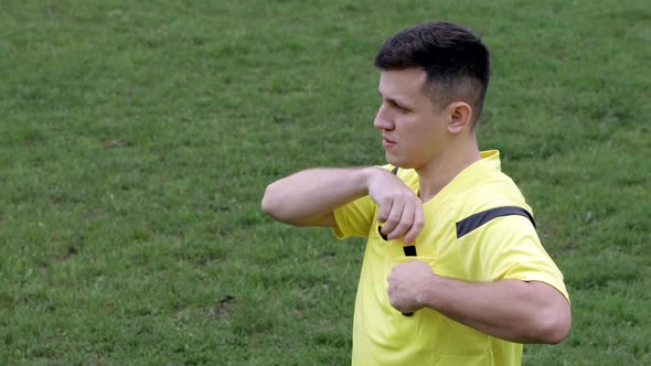 Football Soccer referee whistles and shows penalty and yellow, red card.