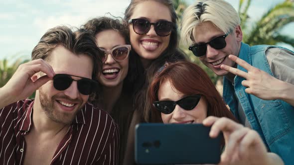 Group of caucasian friends making funny faces for a selfie on music festival. Shot with RED helium c