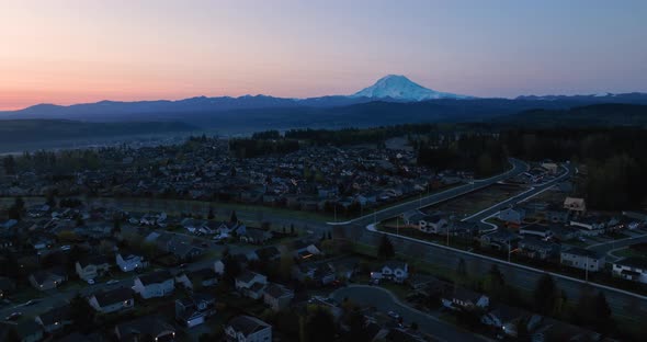 Wide orbiting aerial of a Puyallup neighborhood nestled under the looming presence of Mount Rainier