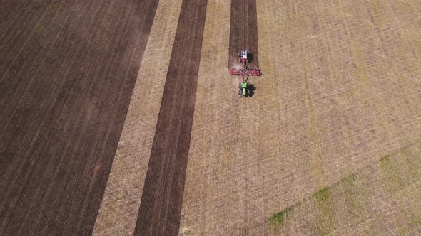 Tractor plowing and fertilizing the agricultural fields in the springtime