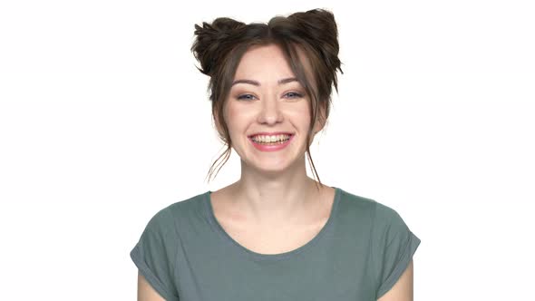 Portrait of Hilarious Woman with Double Buns Hairstyle Making Faces and Grimacing with Showing