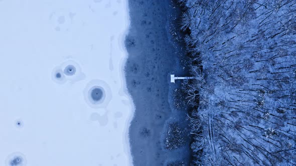Fishing on frozen lake. Winter hobby. Pier and ice holes.