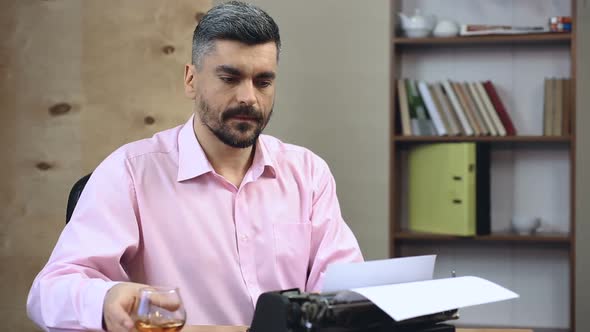 Inspired Novelist Typing the Next Chapter of Bestseller Book, Drinking Cognac