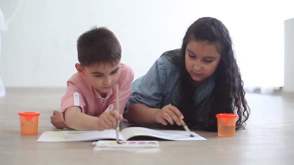 Little Brothers and Sister Paint in the Album Lying on the Floor