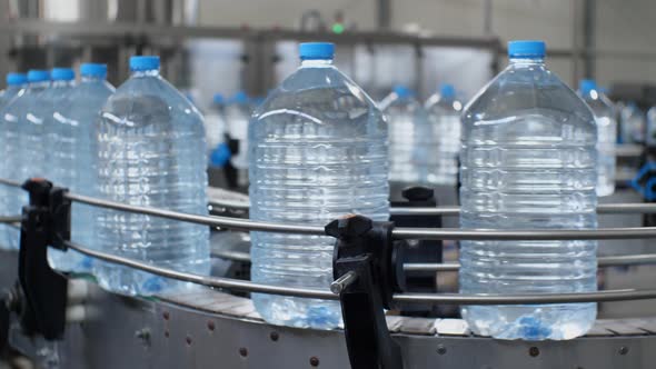 Drinking water production line. Five-liter water bottles move along the conveyor