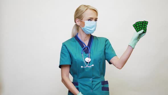 Medical Doctor Nurse Woman Wearing Protective Mask and Rubber or Latex Gloves - Holding Pills