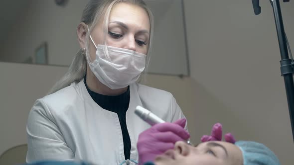 Beautician in White Coat Over Black Pullover Colours Eyebrow