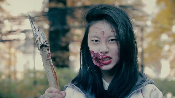 Crazy Female Zombie Murderer With Bloody Axe Looking Aggressively Into Camera