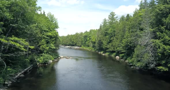 Flying above a river underneath blue skies at Tobey Falls near Willimantic, Maine.