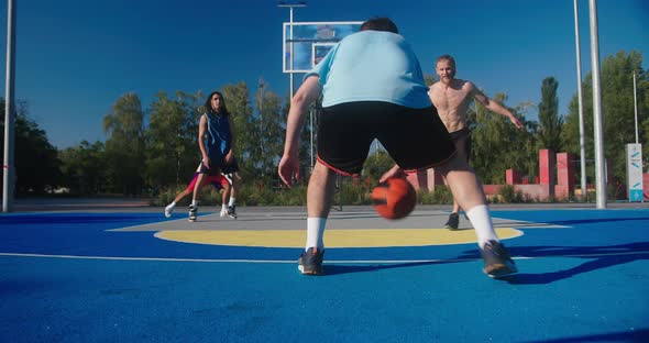 Basketball Players Play Fair Game on Blue Court on Sunny Day