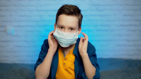 Teenage boy wearing medical mask to protect from infection of viruses