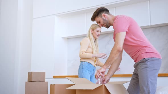 Bearded husband in t shirt takes glasses from brown cardboard package