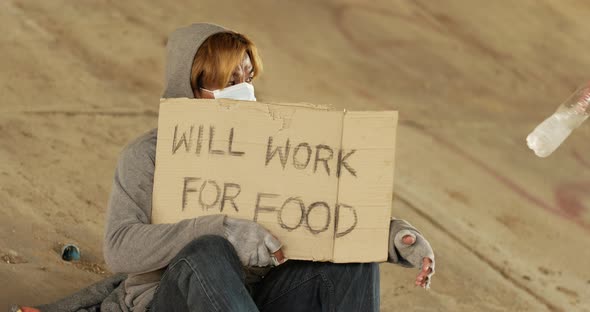 Homeless man holding will work for food label