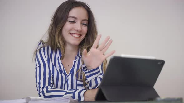 Young woman working remotely at home, communicating with a client