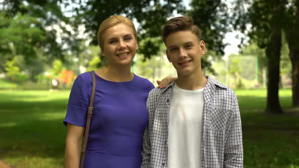 Cheerful Son and Mom Hugging Showing Thumbs-Up, Pleasure Pastime Together