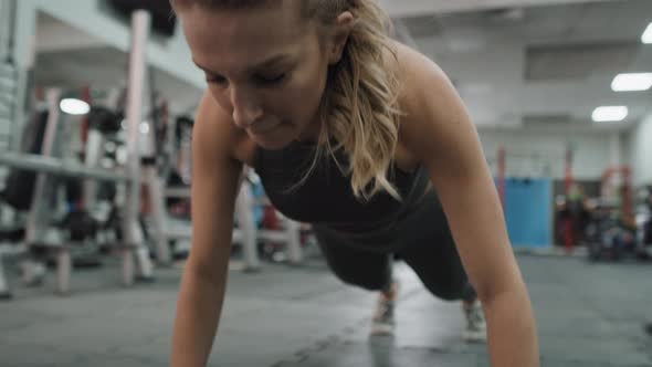 Caucasian woman doing dynamic push ups at the gym. Shot with RED helium camera in 8K.