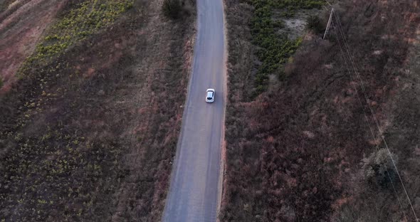 View Of A Car Driving On Road Near Macin Mountains In Tulcea County, Dobrogea, Romania. Aerial Track