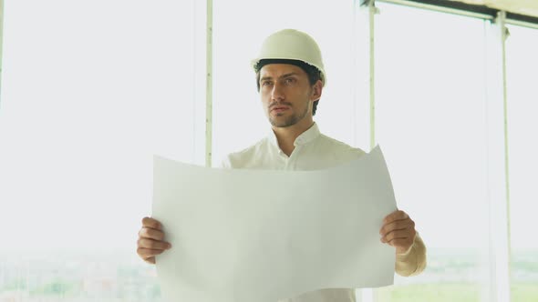 Engineer Builder Architect with Safety Helmet with Drawing Looking on New Building on Site