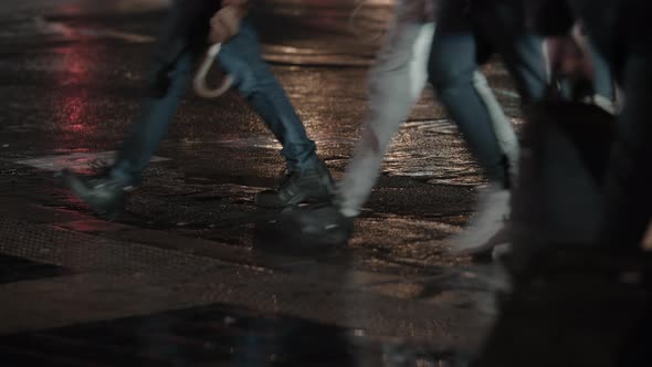 People Crossing the Street Walking on Wet Road in Evening City