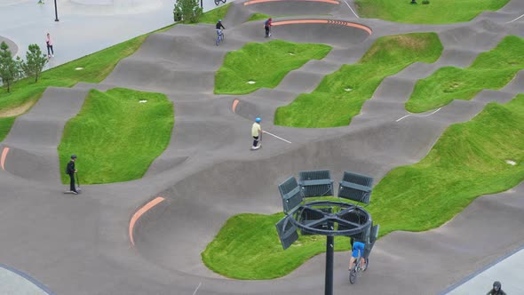 Children Ride Bicycles Scooters in Skatepark