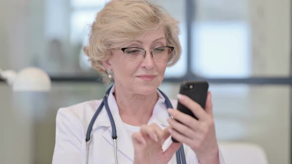 Old Female Doctor Using Smartphone Browsing Internet