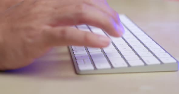 Man typing on keyboard at home