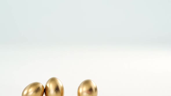 Golden Easter eggs on white background