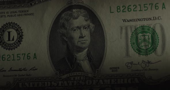 Two Dollar Us Banknote. $ 2 Cash Through A Magnifying Glass. Rotation On A Black Background