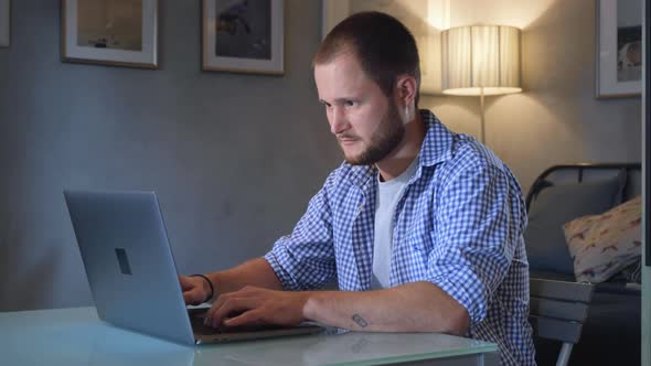 Concentrated serious businessman thinking of problem solution working on laptop