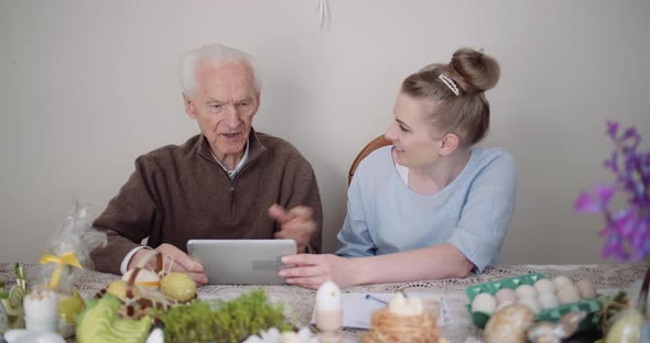 Old Man Retirement - Smiling Senior Man Talking with Granddaughter While Using Digital Tablet