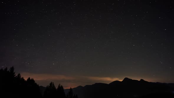 Night starry sky, the Milky Way moving over the mountain landscape.