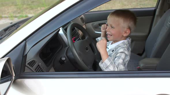 A Little Boy Sitting Behind the Wheel of a Car He Makes Music Louder and Dance
