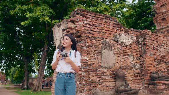 Asian woman using camera for take a picture while spending holiday trip at Ayutthaya, Thailand