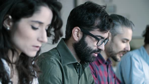 Side View of Cheerful Developer in Eyeglasses Working with Laptop