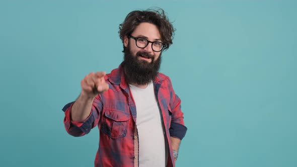 Close Up of Smiling Bearded Man Pointing at You Over Turquoise Background