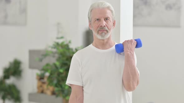 Close Up of Old Man Working Out with Dumbbells at Home