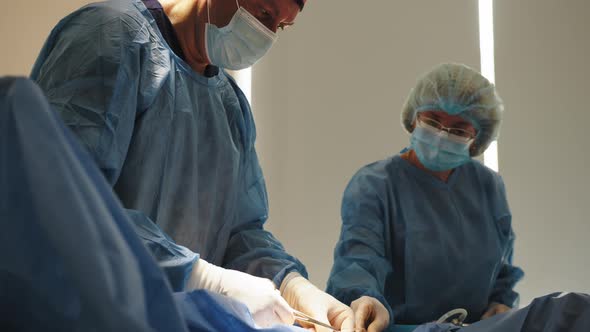 Professional Surgeon Standing in Surgical Mask Preparing a Syringe for Injection