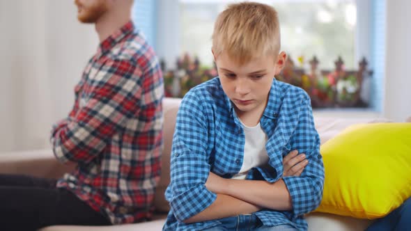 Angry Young Dad and Little Son Have Family Fight Sitting on Couch