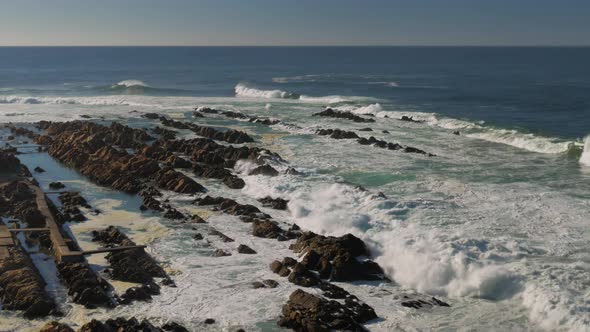 View from high vantage point of rocky coastline with waves breaking  at The Point of Mosselbay, Sout