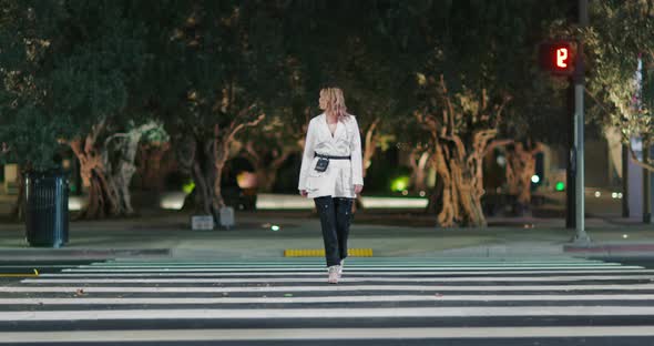 Independent Woman in Stylish Designer Jacket Crossing Road in Night City Footage