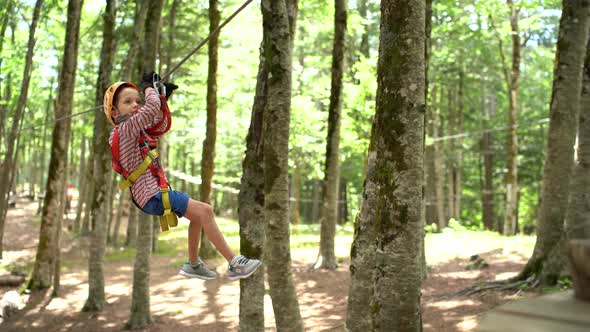 Little Boy Goes Down on a Zipline in an Adventure Park