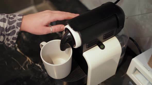 a Woman's Hand Presses a Button on a Small Capsule Coffee Machine and the Coffee Does Not Flow Into