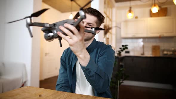 Cute Male Blogger Sitting at a Table at Home Records a Video on the Camera for Subscribers To His